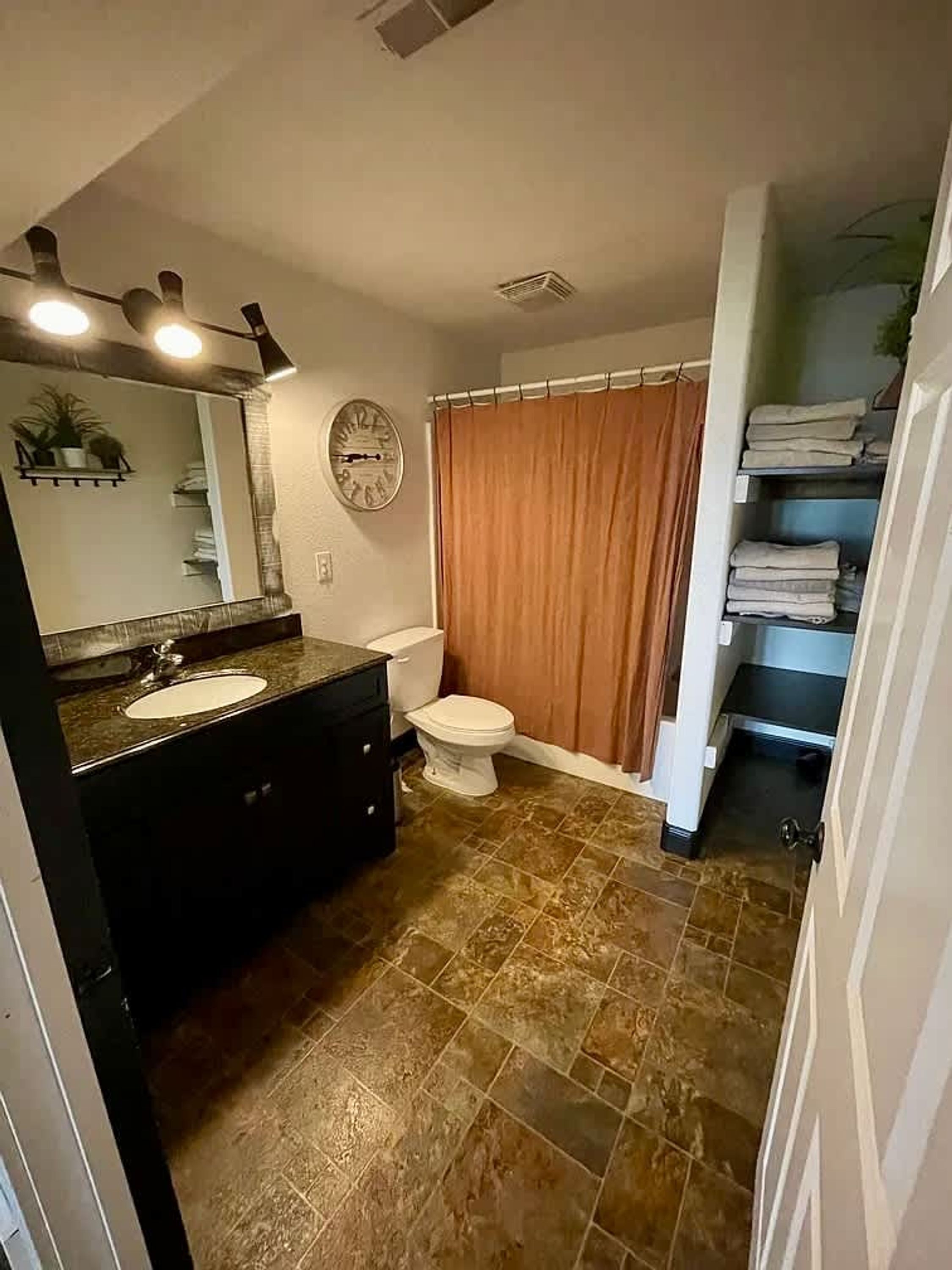 A bathroom with a sink, toilet, and shower curtain.