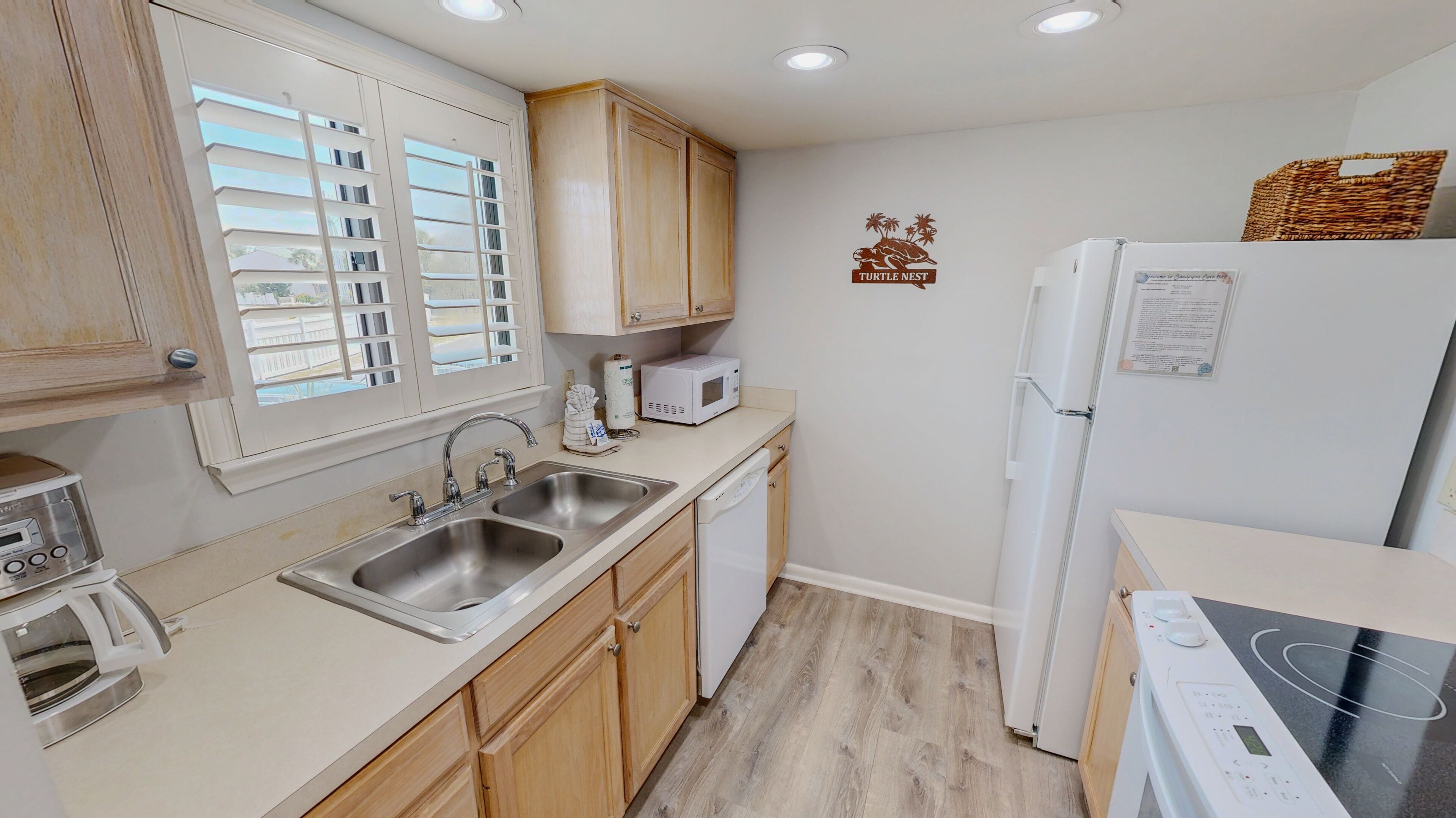A compact kitchen with a sink, microwave, and a refrigerator.