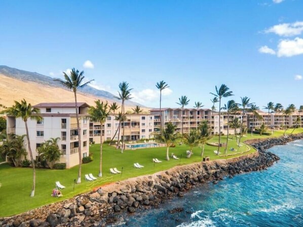 A beachfront hotel with multiple buildings, a pool, and palm trees. - Maalaea Kai #102 1 Bedroom Condo (Wailuku)