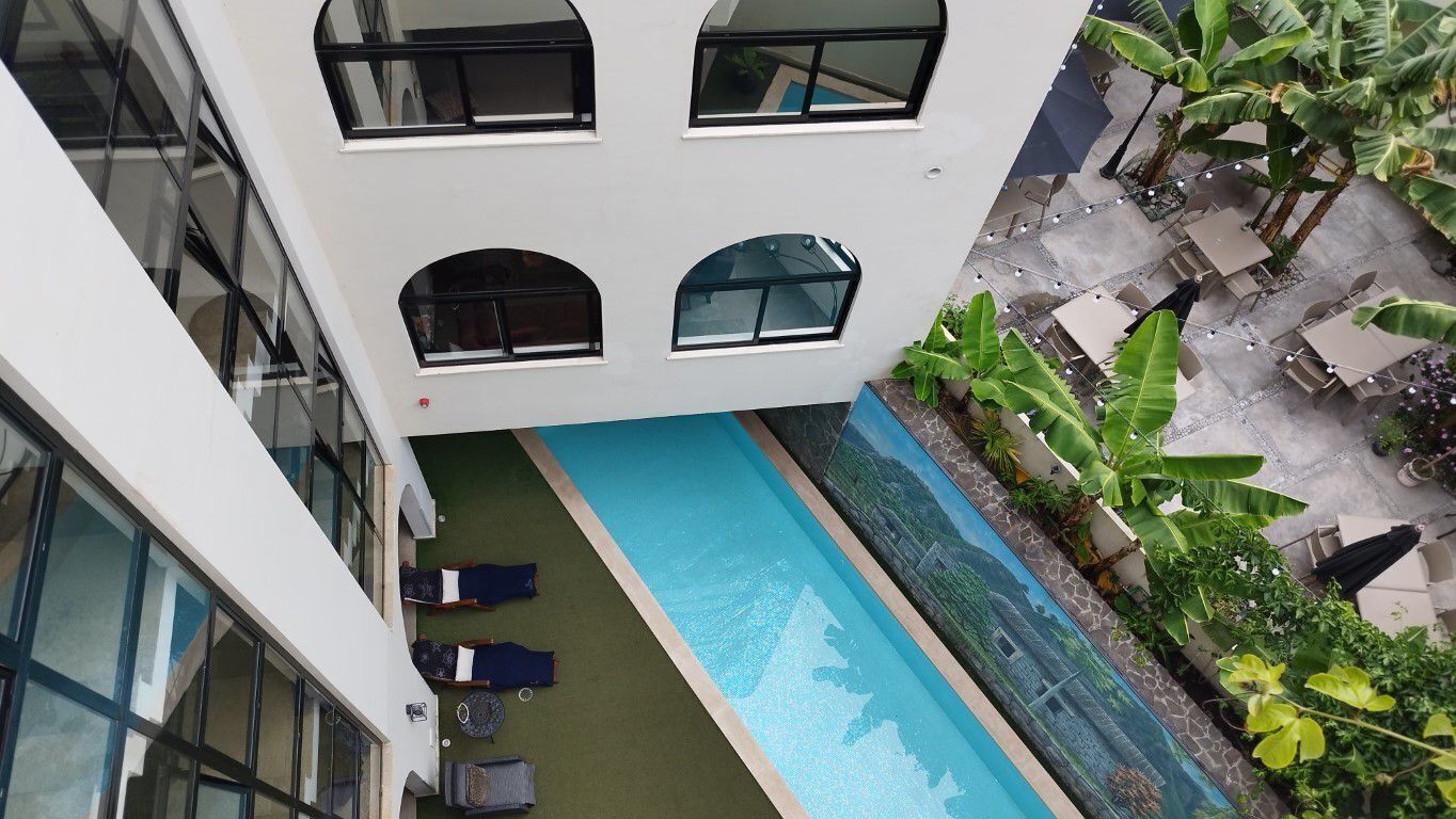 A rooftop pool with lounge chairs and a view of the surrounding buildings.