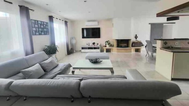 A modern living room with a grey sofa, a coffee table, and a TV.