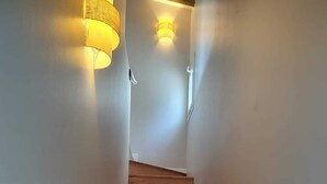 A wooden staircase with a light fixture on the wall.