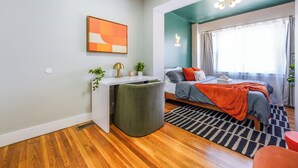 Un dormitorio moderno con cama, mesita de noche y zona de escritorio.