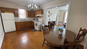 Una cocina amplia con armarios de madera, un refrigerador blanco, una estufa y una mesa de comedor con sillas.