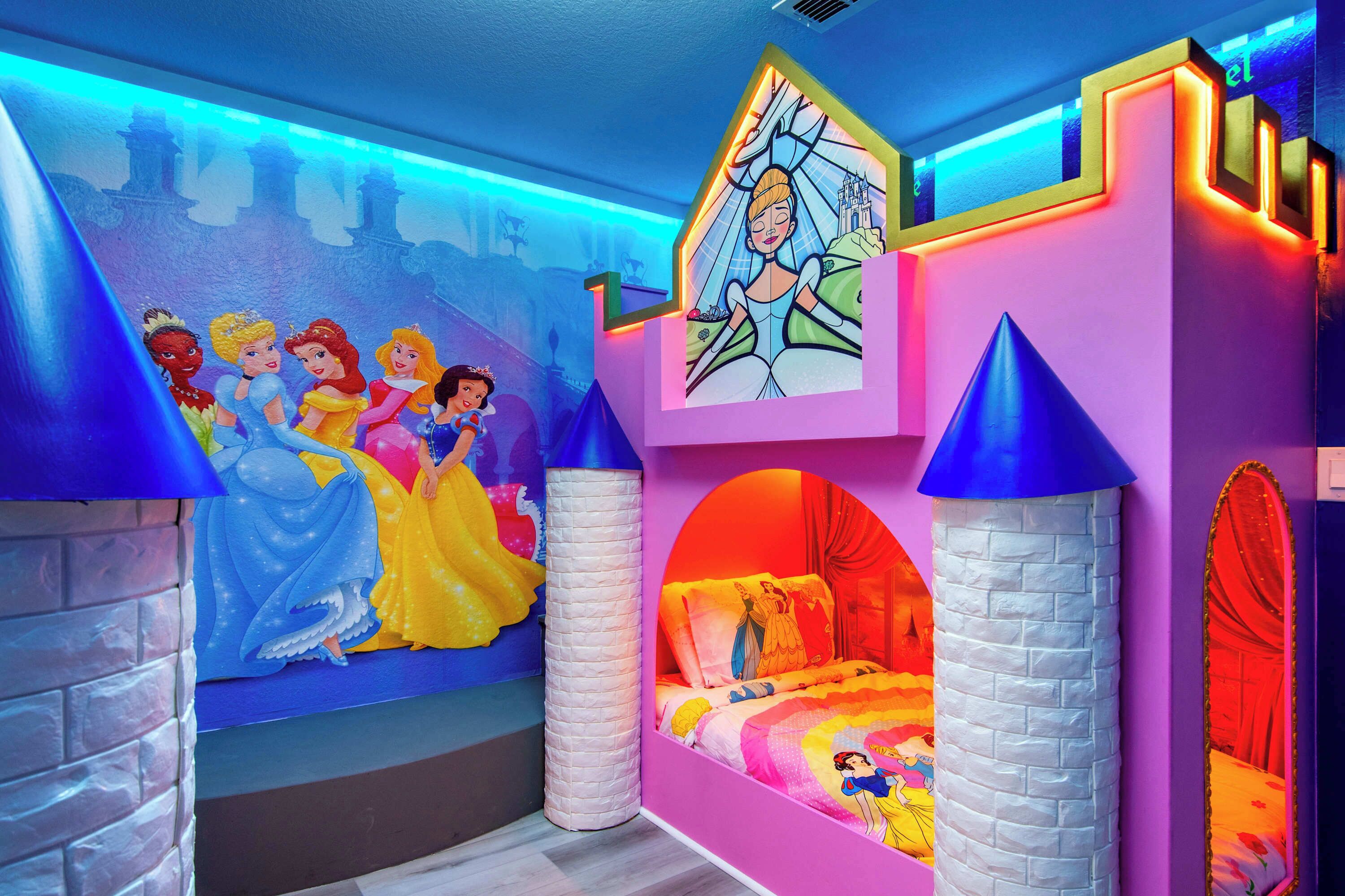 Ein Kinderzimmer mit Wandgemälde von Disney-Prinzessinnen, einem bettenförmigen Schloss und einem großen Fenster mit Blick auf die Skyline der Stadt.