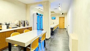 Una cocina moderna con una barra larga, sillas amarillas y una zona de comedor con una mesa grande.