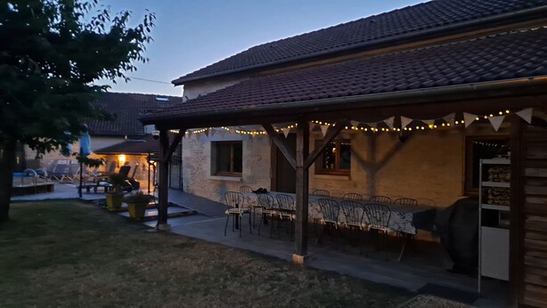 Un patio al aire libre con una zona de estar cubierta y luces colgantes.