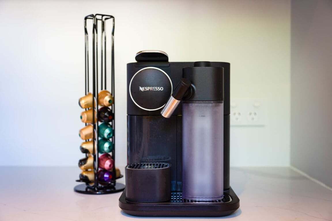 A Nespresso coffee machine with a water reservoir and a coffee pod holder.