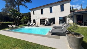 A two-story house with a swimming pool, outdoor seating, and a large potted plant. - Modern villa, fast WiFi, A/C, pool in private backyard, ideal for fun and work (Vallauris)
