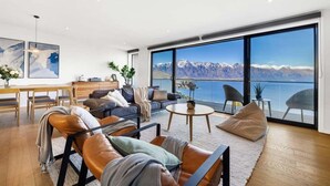 A spacious living room with a large window overlooking a mountainous landscape.