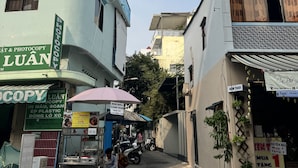 A narrow street with buildings on either side, including a shop with a sign for 'Luân Photocopy'. - B Homeaway Bui Vien (Ho Chi Minh City)