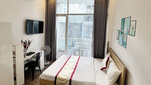 A hotel room with a bed, a desk with a chair, a TV, and a window with curtains. - B Homeaway Bui Vien (Ho Chi Minh City)