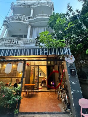 Un bâtiment traditionnel doté d’un balcon, d’une enseigne et d’un vélo garé à l’extérieur.