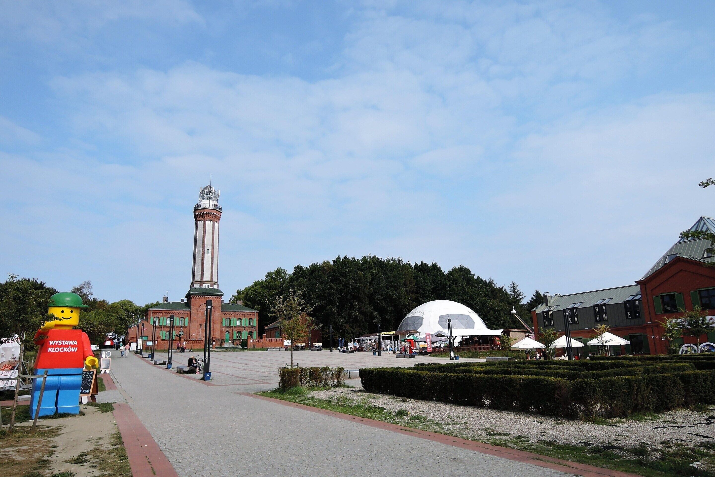 A square with a monument, a large inflatable figure, and a building with a dome.