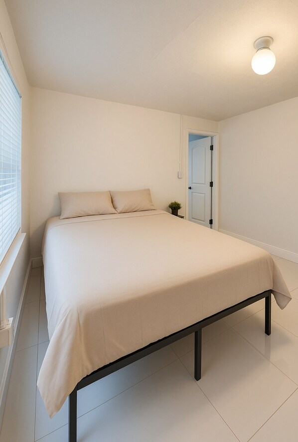 A bedroom with a bed, a window with blinds, and a door. - La sama Wynwood  (Miami)
