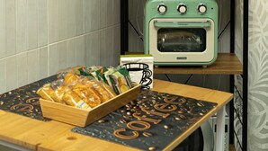 A kitchenette with vintage appliances, including a toaster, a blender, and an oven. There is a tray of bread and a coffee-themed placemat on the counter. - B&B MARGIÒ  (Fiumicino)