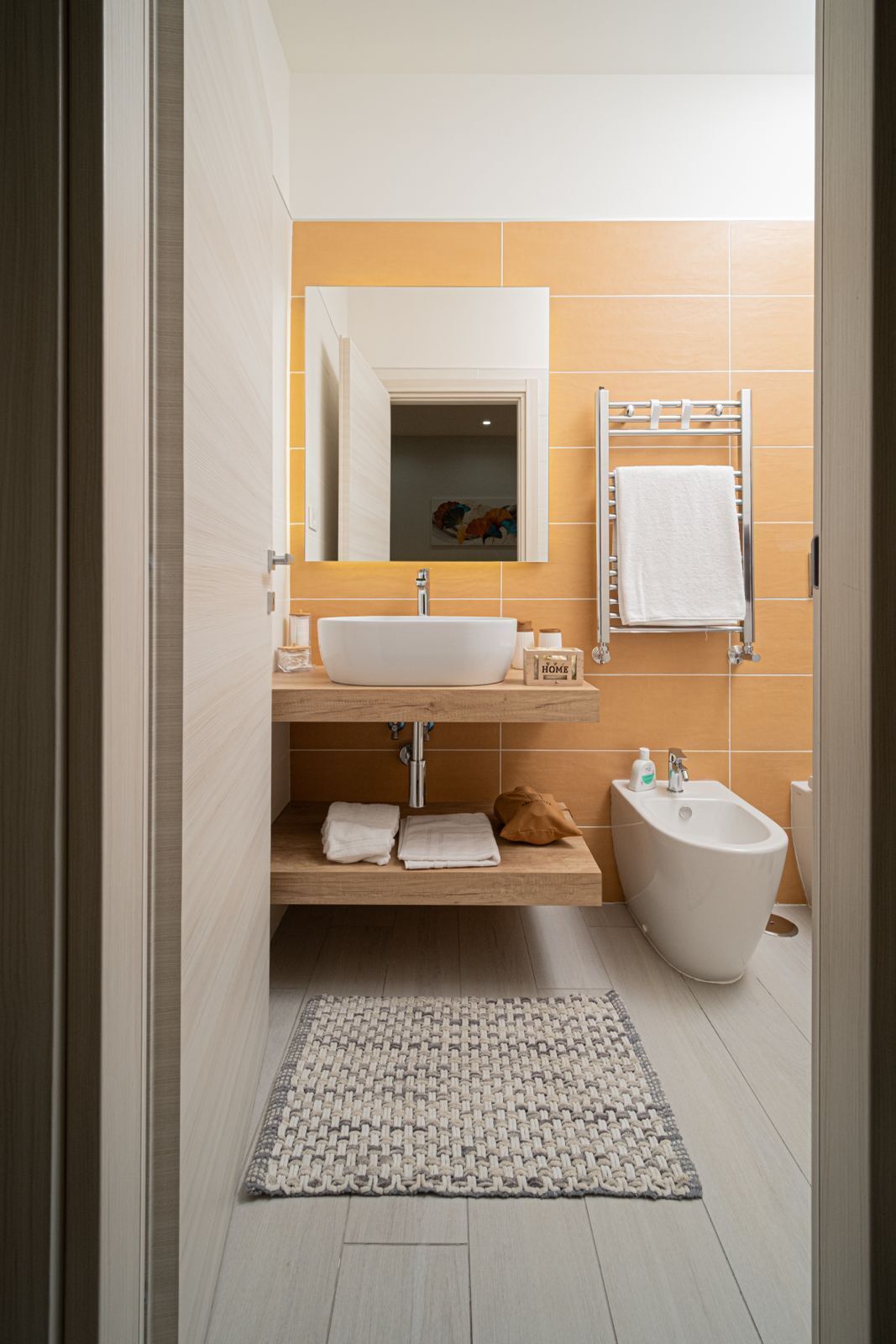 Une salle de bain moderne avec un lavabo blanc, un bidet et un porte-serviettes.