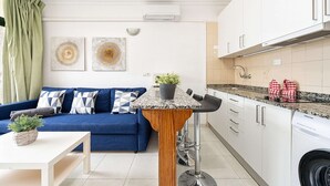 A modern kitchen with white cabinets, a granite countertop, and a built-in dishwasher. - Apartment in Playa del Ingles Near Maspalomas (San Bartolomé de Tirajana)