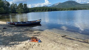 Ein Boot am sandigen Ufer mit Grill und Kochgeschirr.