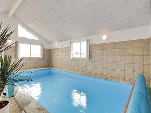 An indoor swimming pool with tiled walls, windows, and a potted plant. - 5 Star Holiday Home in Bogense (Bogense)