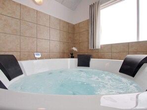 A spa room with a large bathtub, a digital thermometer, and a potted plant. - 5 Star Holiday Home in Bogense (Bogense)