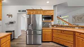 Una cocina moderna con armarios de madera, electrodomésticos de acero inoxidable y un salpicadero de piedra.