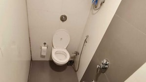 Un baño pequeño y estrecho con inodoro, bidé y secador de manos.