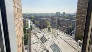 En høj bygning med balkon og udsigt over bybilledet.