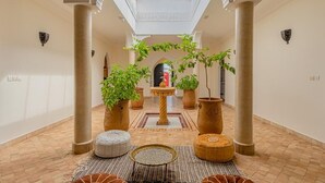 Un vaste espace intérieur doté d’un haut plafond, d’une verrière et d’une fontaine centrale.