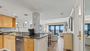 A spacious kitchen with wooden cabinets, granite countertops, and a central island.
