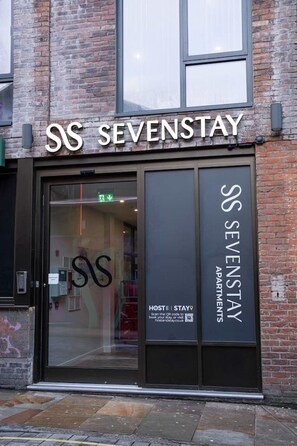 A modern building with a sign reading "SS SEVENSTAY APARTMENTS".