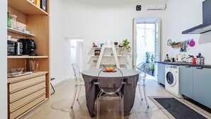 Une cuisine moderne avec une table à manger, des chaises et un lave-linge.