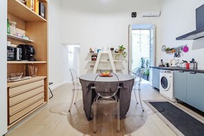 Une cuisine moderne avec une table à manger, des chaises et un lave-linge.