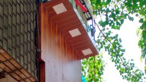 Un edificio de madera con un letrero que dice "JUROTH BLISS INN" y un letrero más pequeño en otro idioma.