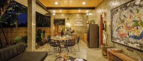 A modern kitchen with a dining area, wooden ceiling, and a large mural.