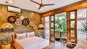 A bedroom with a bed, a ceiling fan, wall decor, and a balcony with a view. - Villa Gaya Ubud (Ubud)