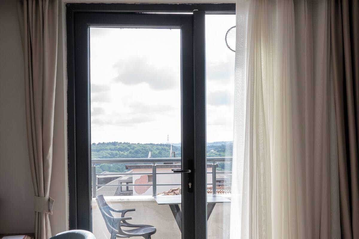 A room with a sliding glass door leading to an outdoor terrace with a table and chairs.