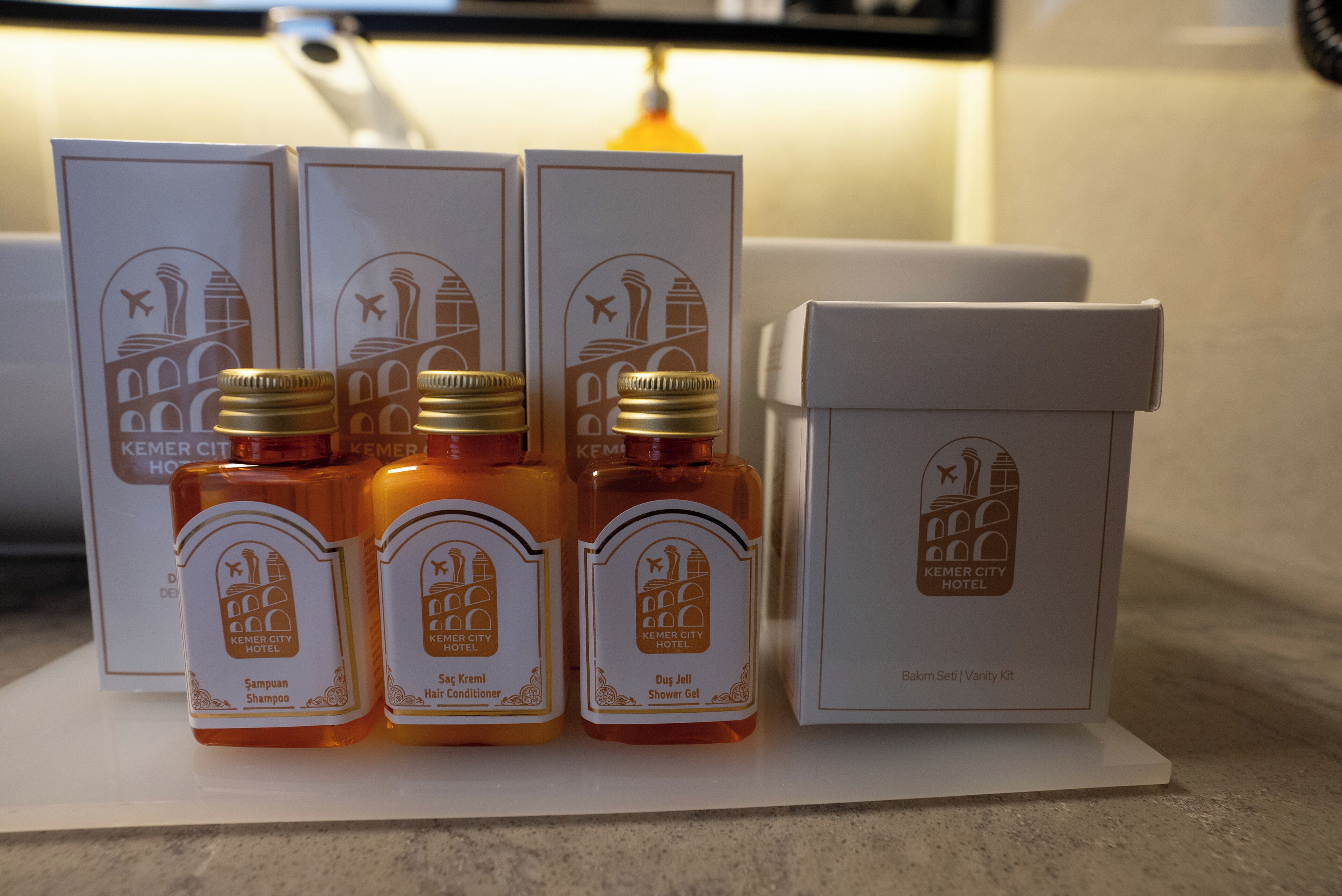 A set of hotel toiletries including shampoo, hair conditioner, and shower gel, each in a labeled box.