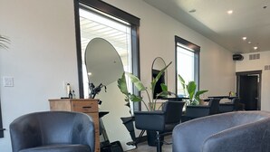 A modern interior with leather chairs, a wooden side table, and a large mirror. - Charming Condo in Star, ID, near shopping , Dining, spas and salon, with WiFi (Star)