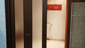 Una habitación con puerta de madera, suelo de baldosas y pared con diseño decorativo.