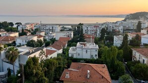 A coastal residential area with buildings, some with red-tiled roofs, and a view of the sea and a bridge in the distance. - SEASIDE Apartement, Calm, chill, Nice (Nice)