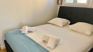 A neatly made bed with white linens, two pillows, and a blue blanket. - SEASIDE Apartement, Calm, chill, Nice (Nice)