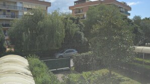 Ein Wohngebäude mit mehreren Balkonen und einem geparkten Auto davor.