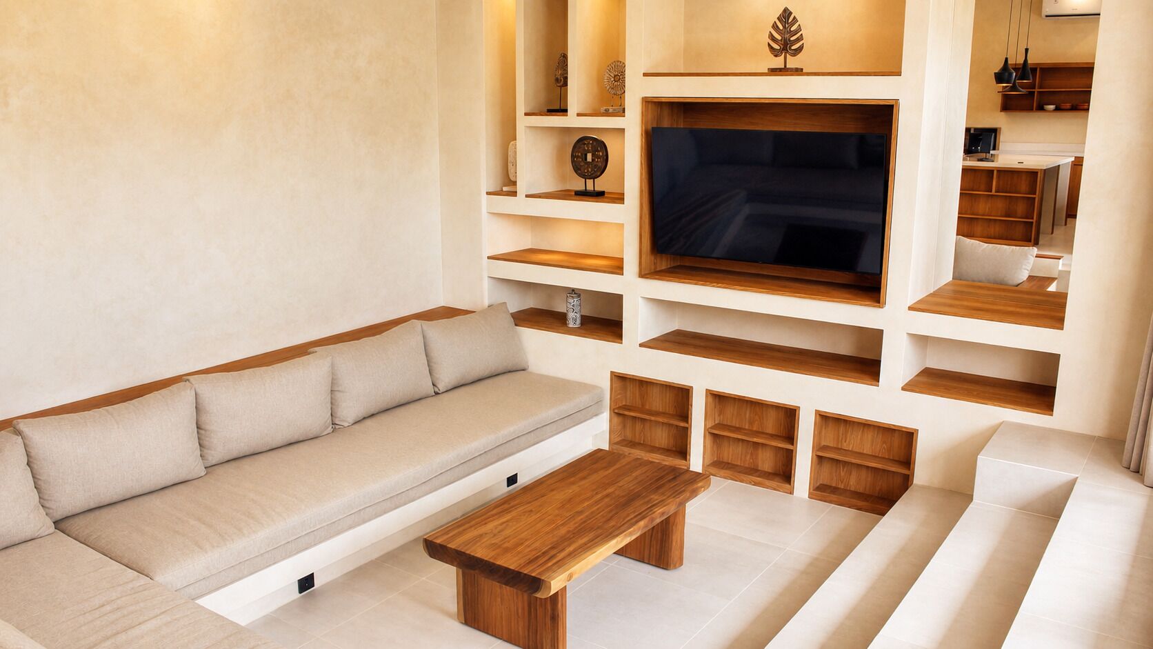 A modern living room with a sofa, a coffee table, and built-in shelves.