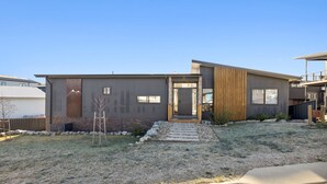 A modern two-story house with a stone facade, a wooden deck, and a well-maintained lawn. - The Crystal Palace 2, pet friendly 2 bedroom apartment (Jindabyne)