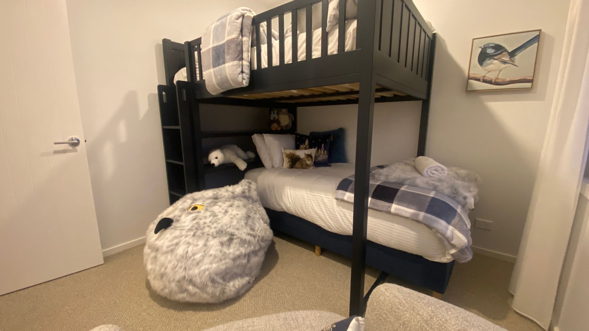 A bunk bed room with a plush dog bed, pillows, and a stuffed animal.