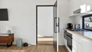 A modern kitchen with white cabinets, a wooden countertop, and stainless steel appliances. - The Crystal Palace 2, pet friendly 2 bedroom apartment (Jindabyne)