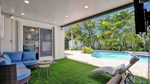 A modern outdoor living area with a pool, green artificial grass, and lounge chairs. - Dania Beach 4BR • Pool • Game Room • Discounted! (Dania Beach)