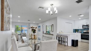 A modern kitchen with white cabinets, a microwave, and a stove. - Dania Beach 4BR • Pool • Game Room • Discounted! (Dania Beach)