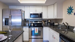 A modern kitchen with stainless steel appliances, white cabinets, and a skylight. - Foxtail Palm: Steps from the beach (Holmes Beach)